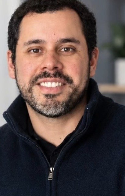 Dr. Eduardo Rocha, médico endocrinologista, sorrindo em seu consultório